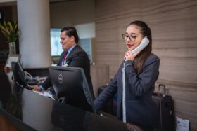 Hotel employees at a front desk.