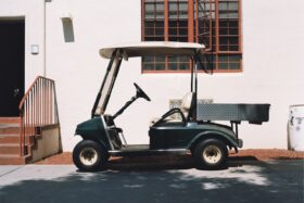 Parked golf cart next to a building.